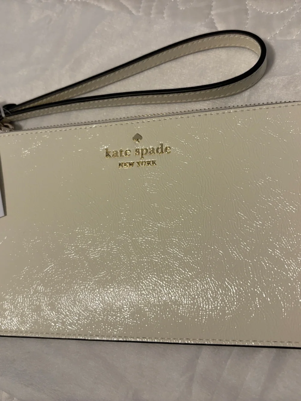 kate spade cream patent leather wristlet with gold logo