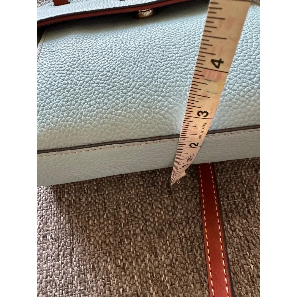 This is a Dooney & Bourke Pebble Grain East/West Flap Crossbody in a light blue